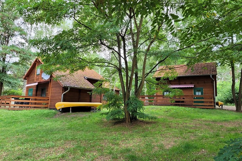 Ein idyllisches Holzhaus umgeben von Natur und einem gepflegten Garten.