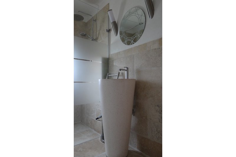 Bad mit italienischer Dusche, Waschbecken und separater Toilette.