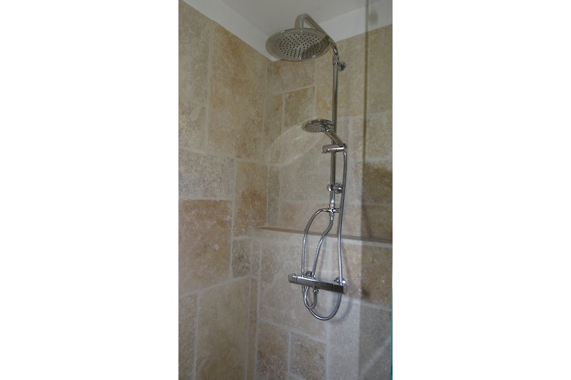 Bad mit italienischer Dusche, Waschbecken und separater Toilette.