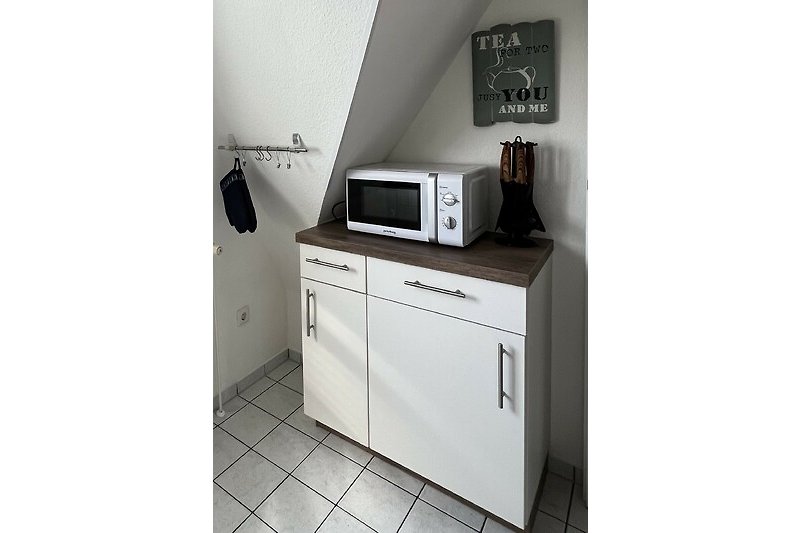 Küche Teilansicht mit Mikrowelle und Mülleimerschrank