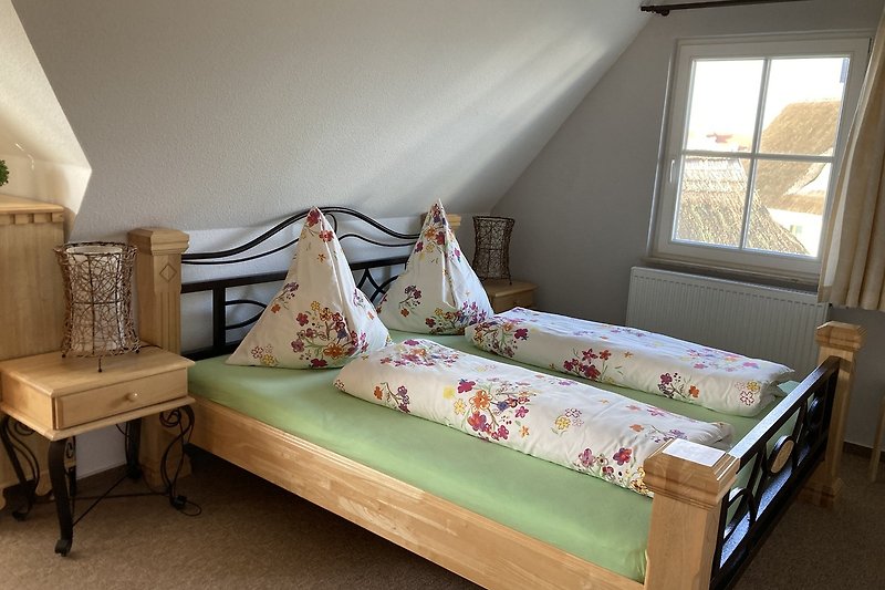 Gemütliches Schlafzimmer mit Holzmöbeln und gemütlichem Bettzeug.