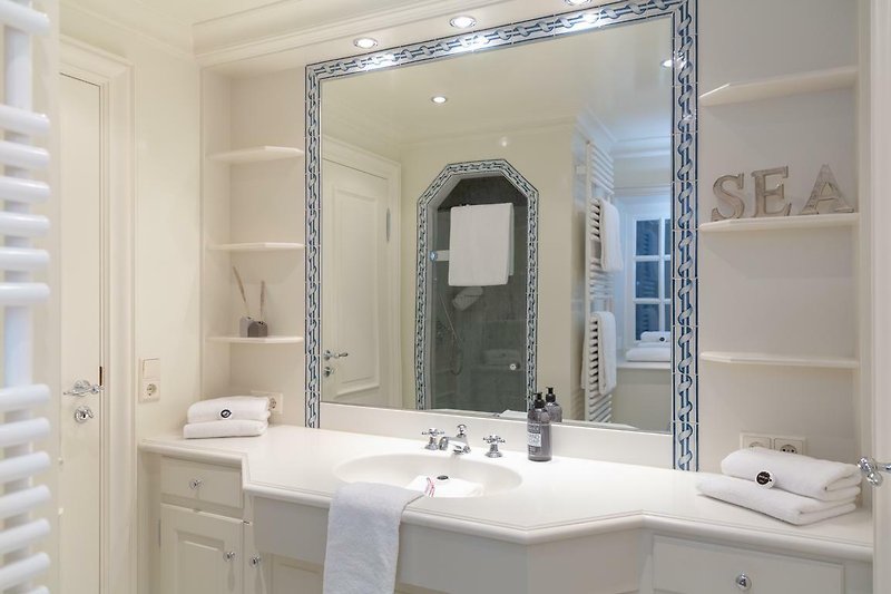 Schönes Badezimmer im stilvollem Design mit Dusche WC und beleuchtetem Spiegel.