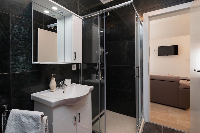Schönes Badezimmer mit Spiegel, Waschbecken und Armaturen.