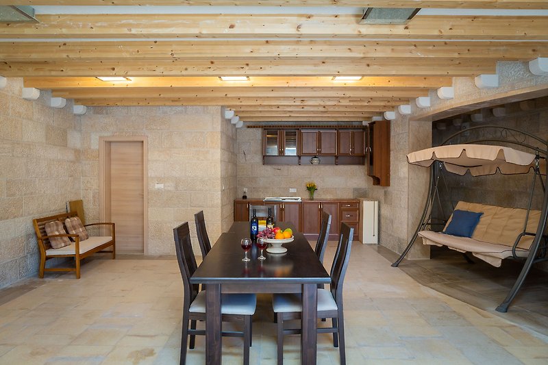 Schönes Haus mit Holzboden, Tisch und Stühlen in der Küche.