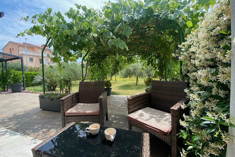 Ein idyllischer Garten mit gemütlichen Gartenmöbeln und einer schönen Aussicht.