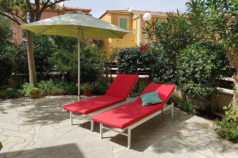 Eine komfortable Terrasse mit Gartenmöbeln und Sonnenschirm.