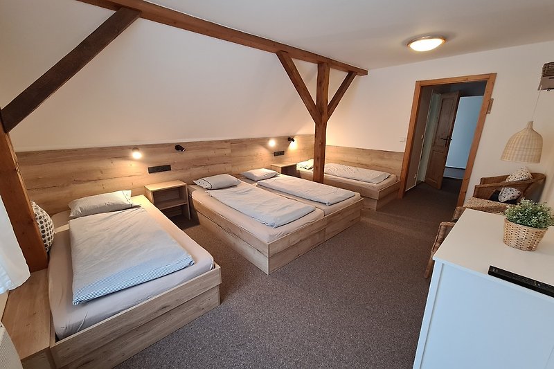 Schlafzimmer mit Himmelbett, Holzmöbeln und Blumen - perfekt für Entspannung.