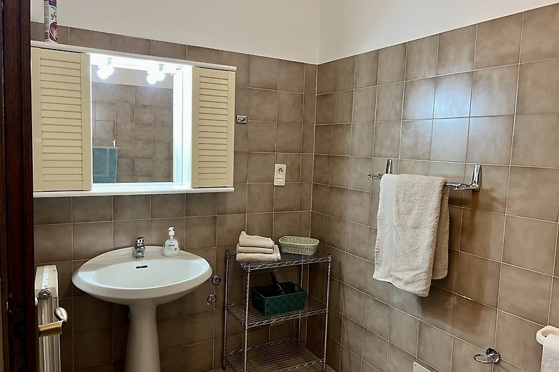 Modernes Badezimmer mit elegantem Waschbecken und Spiegel.