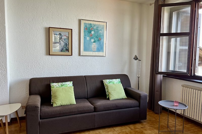 Stilvolles Wohnzimmer mit gemütlicher Couch und großem Fenster.