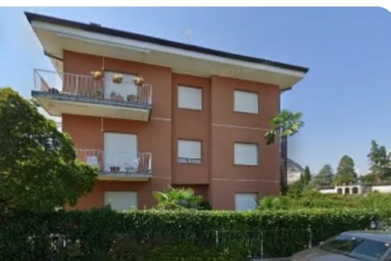 Apartment mit Balkon, Palmen, Einfahrt und Hacienda-Villa Flair.