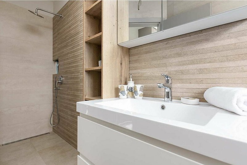 Badezimmer mit braunem Holz, Spüle, Spiegel und Waschbecken.