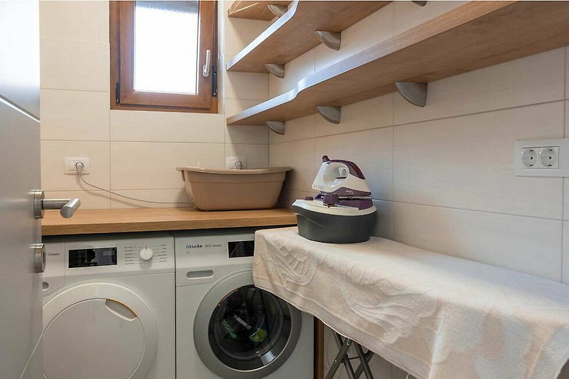Gemütliche Waschküche mit modernen Geräten und stilvoller Beleuchtung.