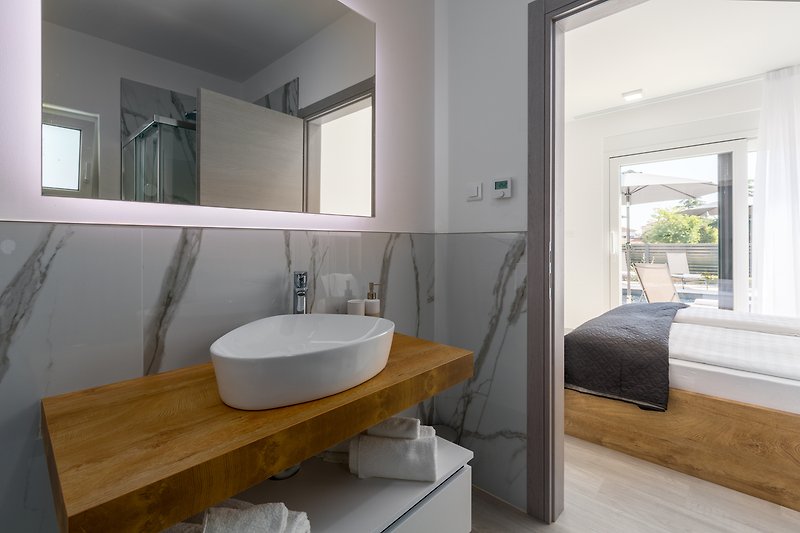 Schönes Badezimmer mit stilvollem Waschbecken und Glaswand.