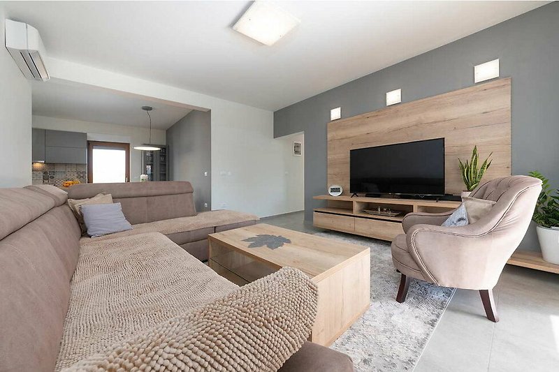 Gemütliches Wohnzimmer mit Holzmöbeln, Couch und stilvoller Beleuchtung.