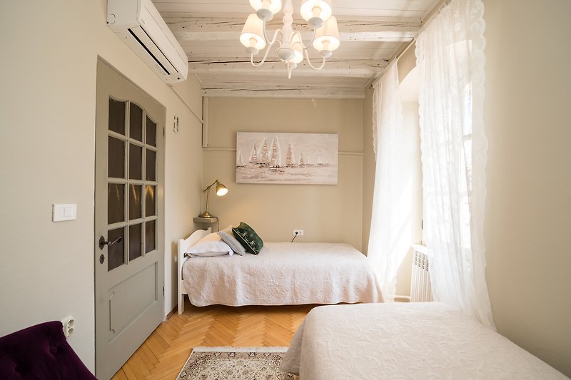 Stilvolles Schlafzimmer mit Holzmöbeln, Bett, Fenster und Lampen. Gemütliche Atmosphäre!