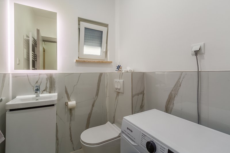 Gemütliches Badezimmer mit modernem Waschbecken und Holzschrank.