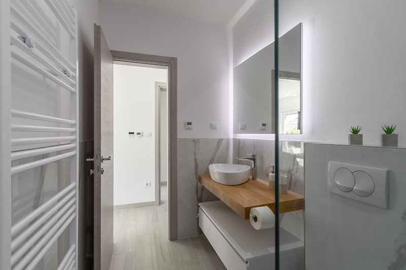 Schönes Badezimmer mit stilvollem Waschbecken und Holzschrank.