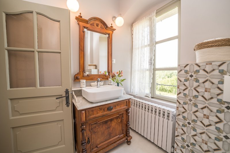 Badezimmer mit Spiegel, Schrank und Waschbecken - stilvolle Einrichtung!