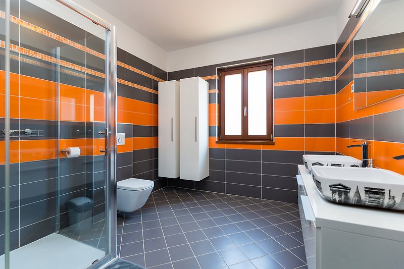 Gemütliches Badezimmer mit stilvollem Interieur und glänzenden Armaturen.