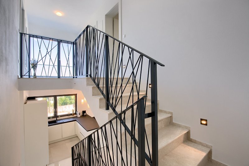 A beautifully designed interior with wooden stairs and a glass baluster.