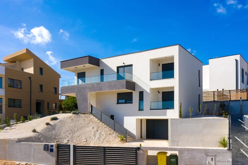 Een modern stadsgebouw met blauwe ramen en een groen landschap.