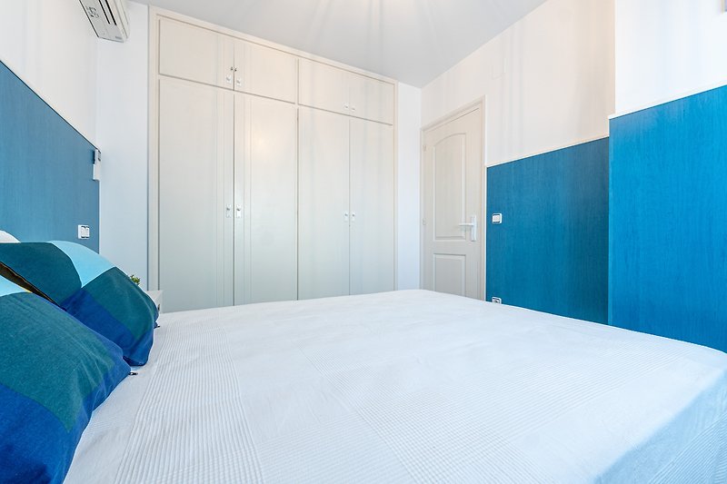 Gemütliches Schlafzimmer mit blauem Interieur und Holzmöbeln.