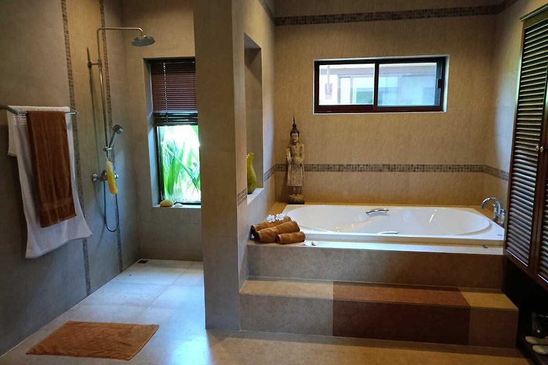 Modernes Badezimmer mit Badewanne, Fenster und Holzdetails.