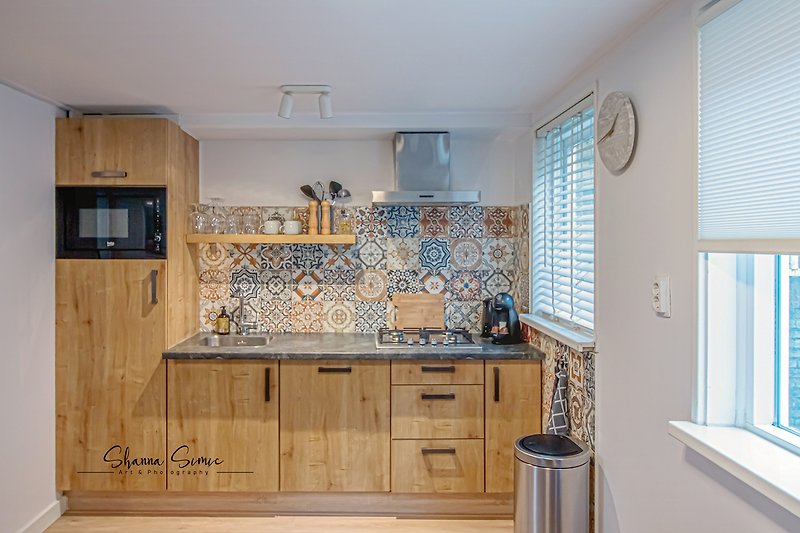 Moderne keuken met houten kasten en aanrechtblad.