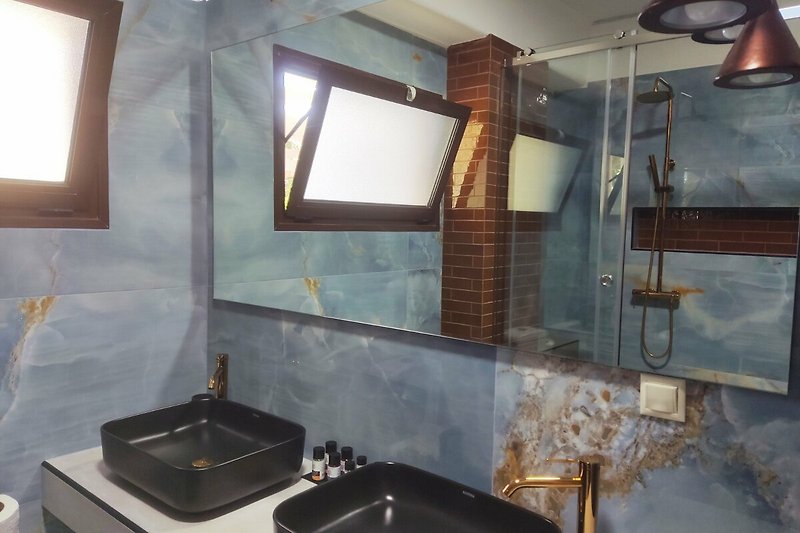 Modernes Badezimmer mit stilvoller Beleuchtung, edlem Holz und elegantem Design.