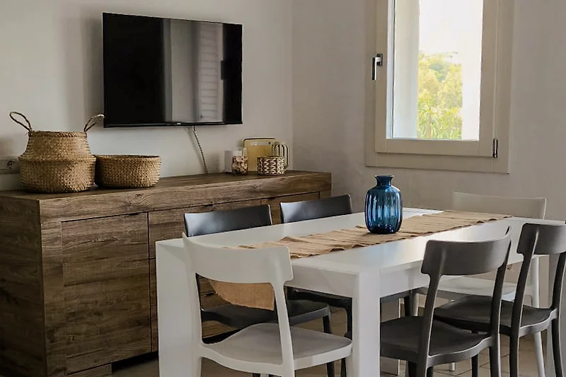 Essbereich mit großem Holztisch, Pflanzen, Regalen und Obstschale.