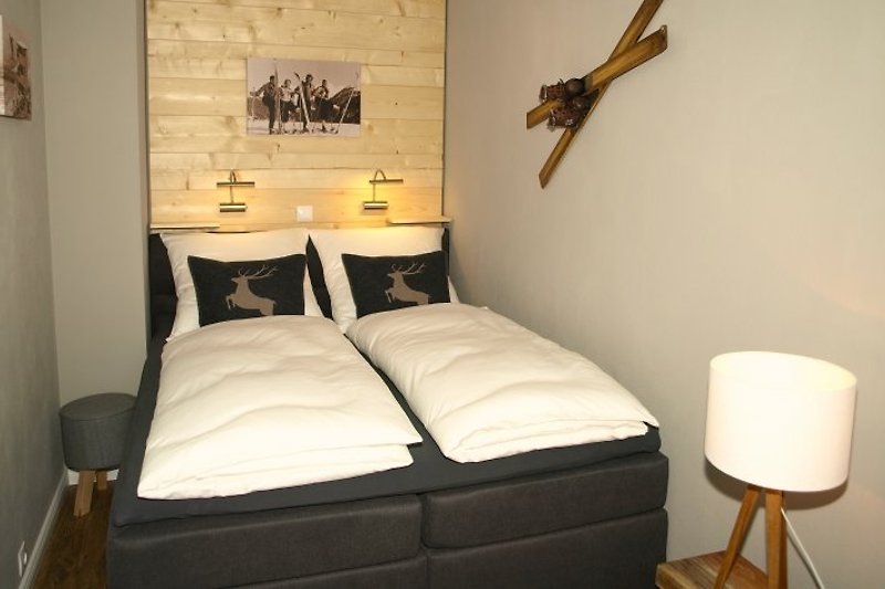 El área de dormitorio estilo chalet amueblada con cama box spring.