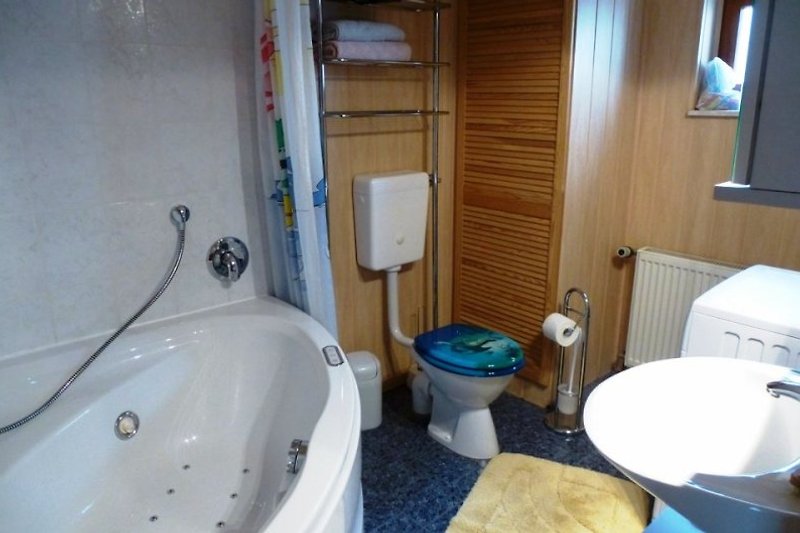 Das Badezimmer im Untergeschoss ist ausgestattet mit einer Whirlwanne, die durch einen Duschvorhang auch sehr gut als Dusche genutzt werden kann.