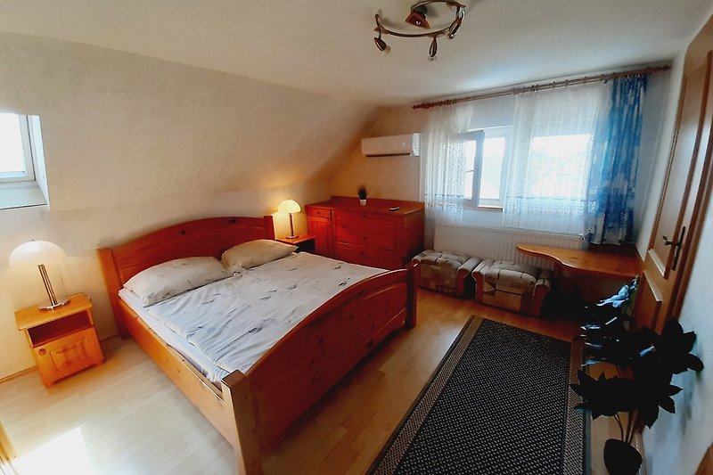 Gemütliches Schlafzimmer mit stilvollem Bett und Holzmöbeln.
