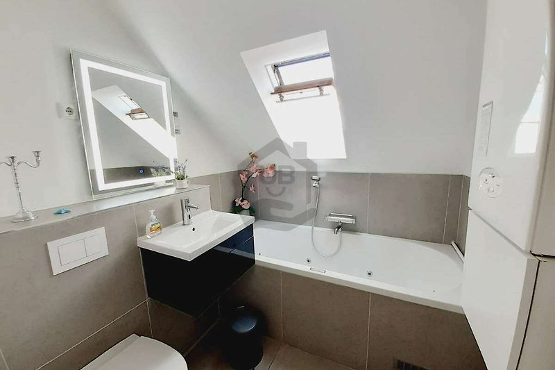 Schönes Badezimmer mit Spiegel, Waschbecken und modernen Armaturen.