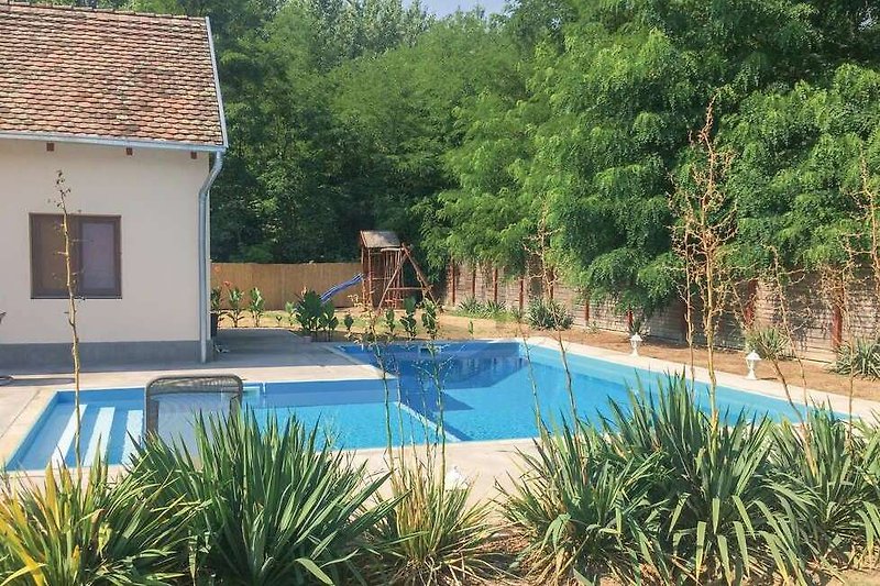 Schwimmbad mit Sonnenliegen und Palmen in einer Ferienanlage. Erholung am Pool.