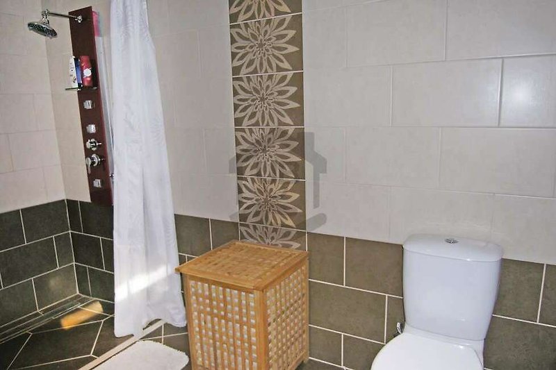 Schönes Badezimmer mit Fliesen, Marmor und Glas.