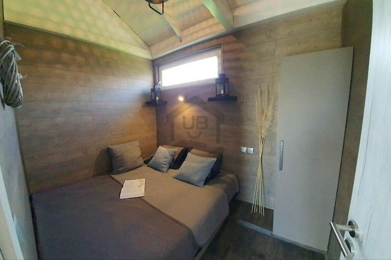 Gemütliches Schlafzimmer mit stilvollem Holzbett und schöner Beleuchtung.