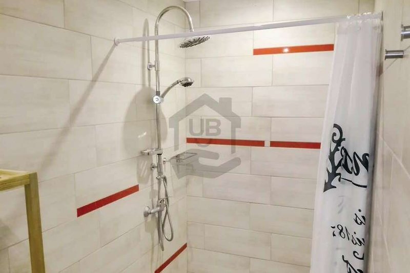 Ein modernes Badezimmer mit Dusche, Armaturen und Glasduschtür.