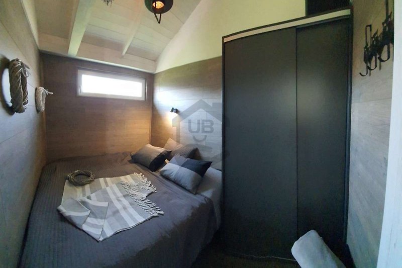 Stilvolles Schlafzimmer mit gemütlichem Bett und hellem Holz.