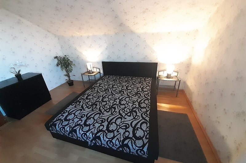 Gemütliches Schlafzimmer mit stilvoller Einrichtung und bequemem Bett.