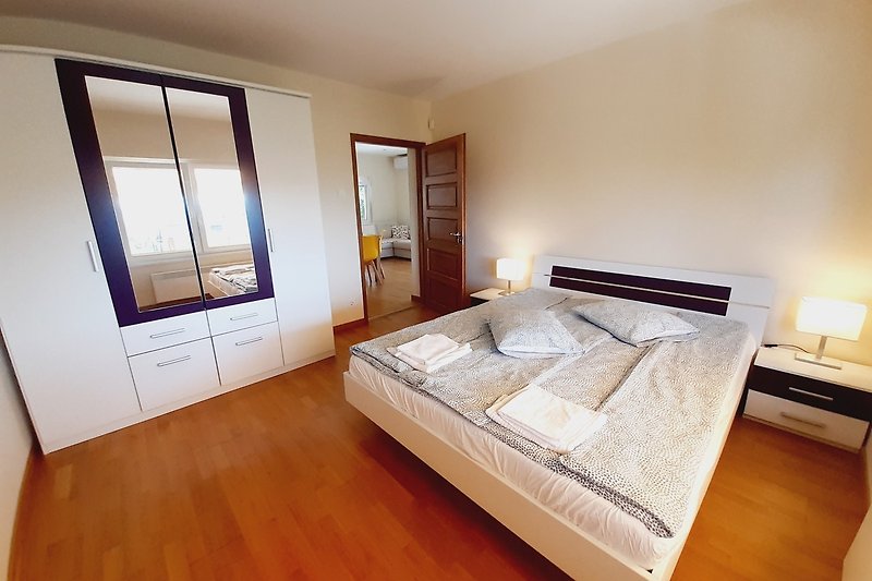 Stilvolles Ferienhaus mit Holzinterieur, Fenstern und gemütlichem Bett.