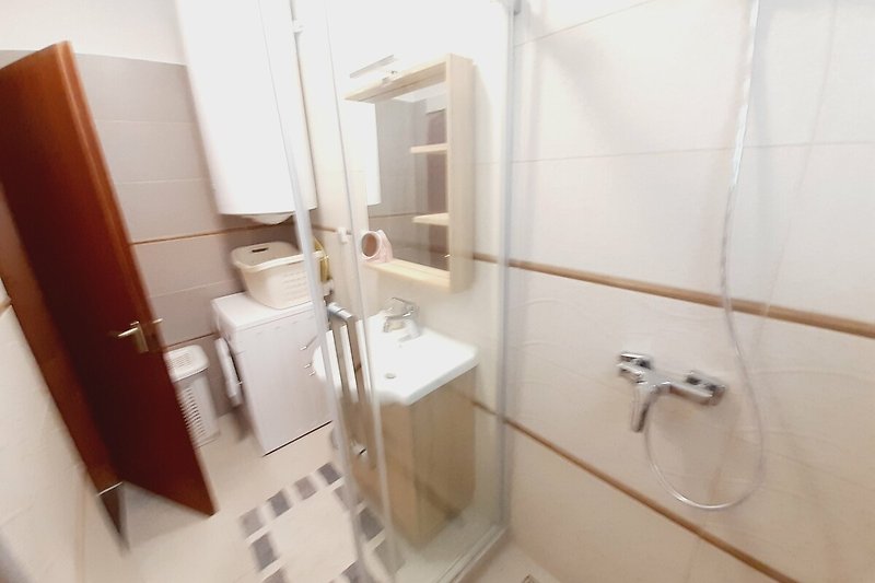 Modernes Badezimmer mit stilvoller Ausstattung und elegantem Spiegel.