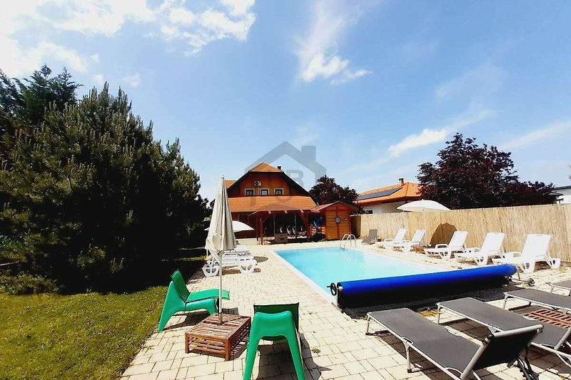 Schönes Ferienhaus mit Pool und Sonnenliegen in einer Resortstadt. Perfekt für einen entspannten Urlaub.