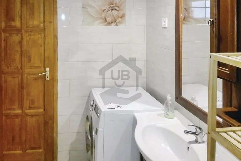 Ein stilvolles Badezimmer mit Holzboden und modernen Armaturen.