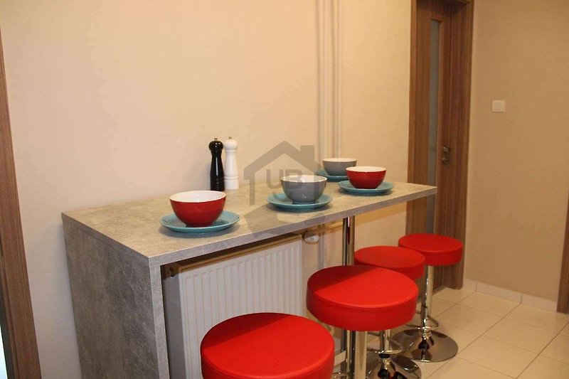 Moderne Küche mit Barhockern, Holztisch und Stühlen.