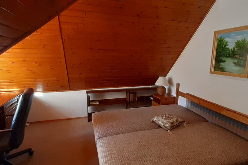 Geräumiges Wohnzimmer mit Holzdecke und Pflanzen.