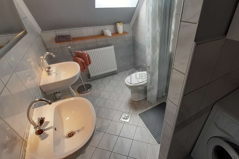 Schönes Badezimmer mit Spüle, Spiegel und Toilette.