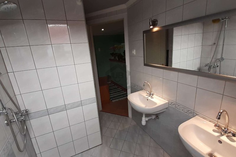 Schönes Badezimmer mit Spiegel, Spüle und Armaturen.