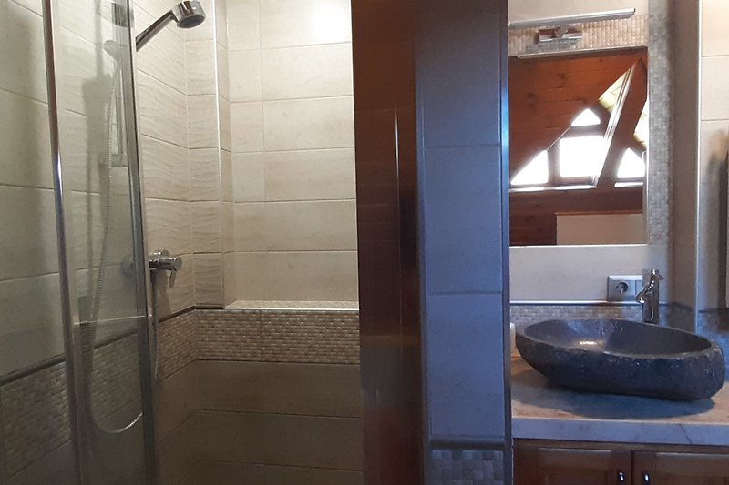 Luxuriöses Badezimmer mit moderner Dusche und elegantem Spiegel.