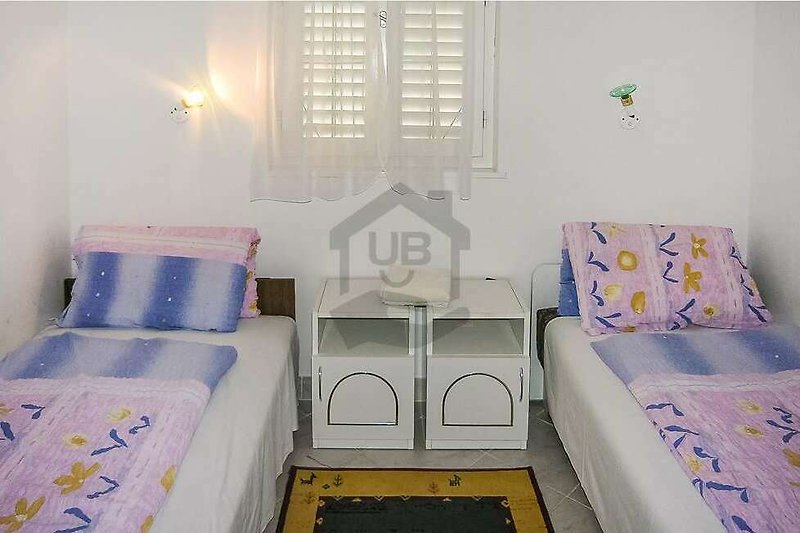 Gemütliches Schlafzimmer mit blauer Bettwäsche und Holzmöbeln.